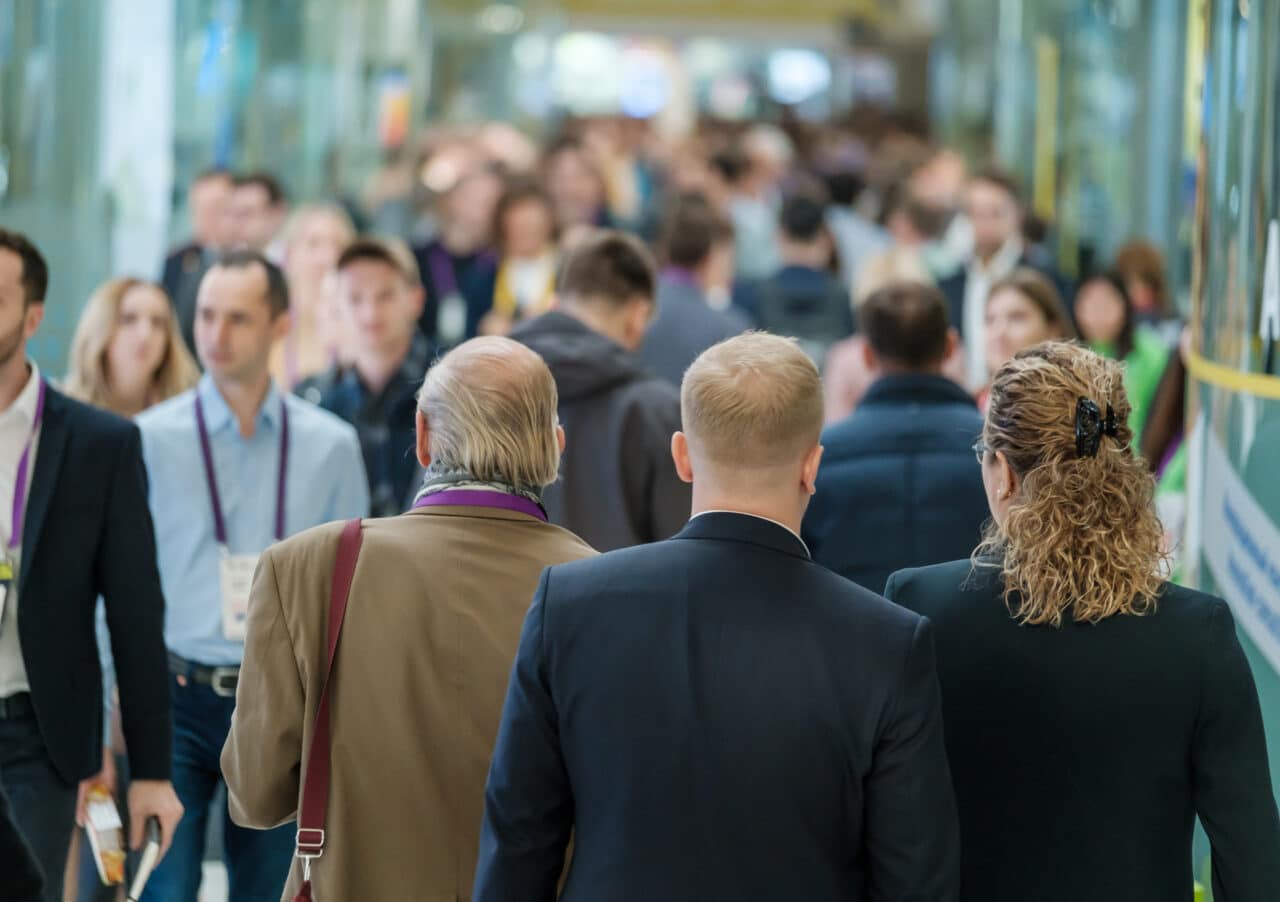 Crowd of people walking indoors, defocused,